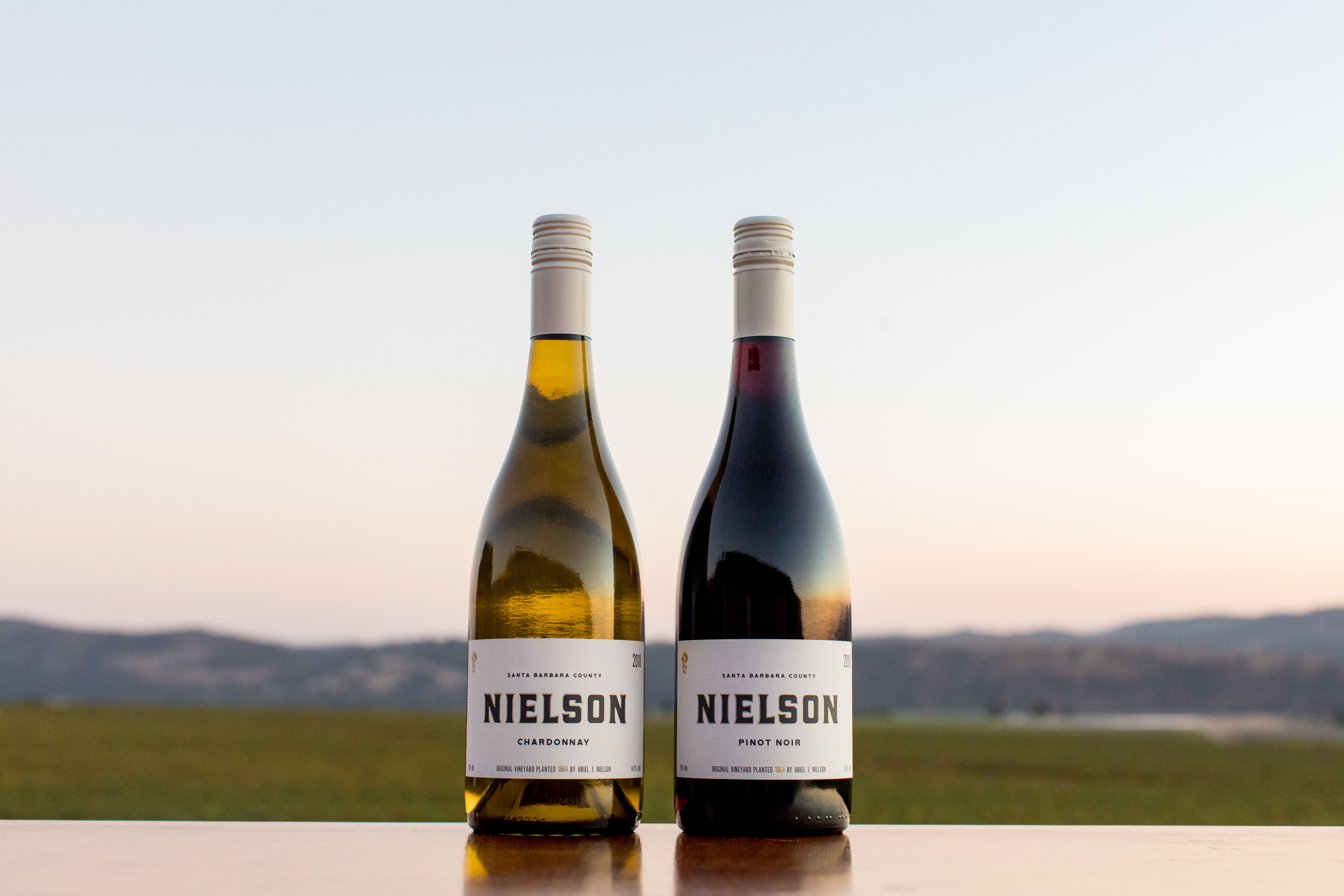 Two Nielson wines on a blanket on the beach