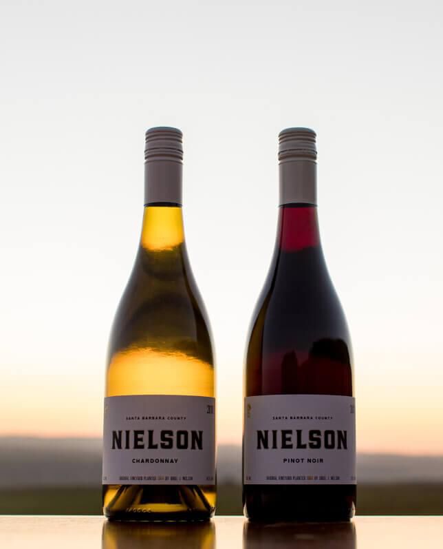 Two Nielson Wine bottles with sunset in background